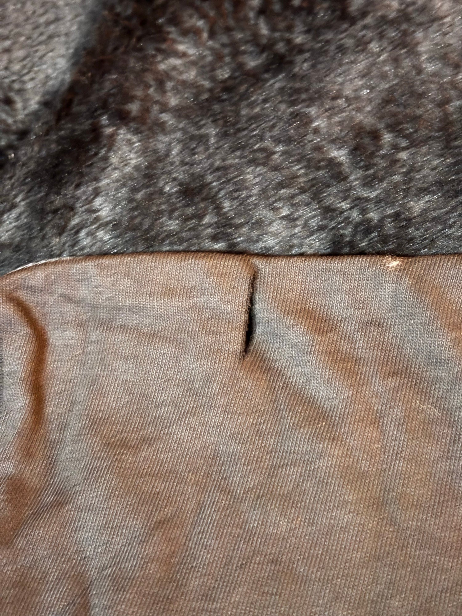 Small snip near the bottom hem (disclosed flaw)